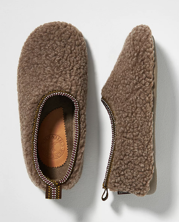 A pair of fuzzy slippers lined with brown bouclé fabric