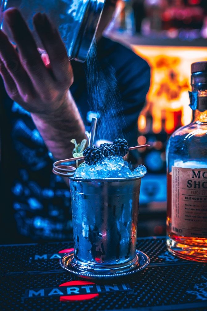 Someone mixing a cocktail at a bar