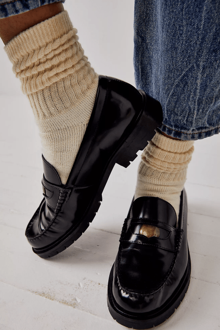 A model wearing crew socks and black Free People loafers