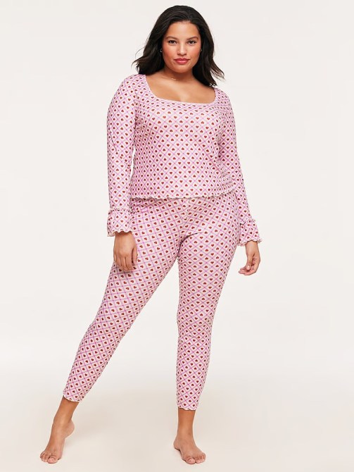 A model wearing a pink, heart-print pajama set from Adore Me at Victoria's Secret