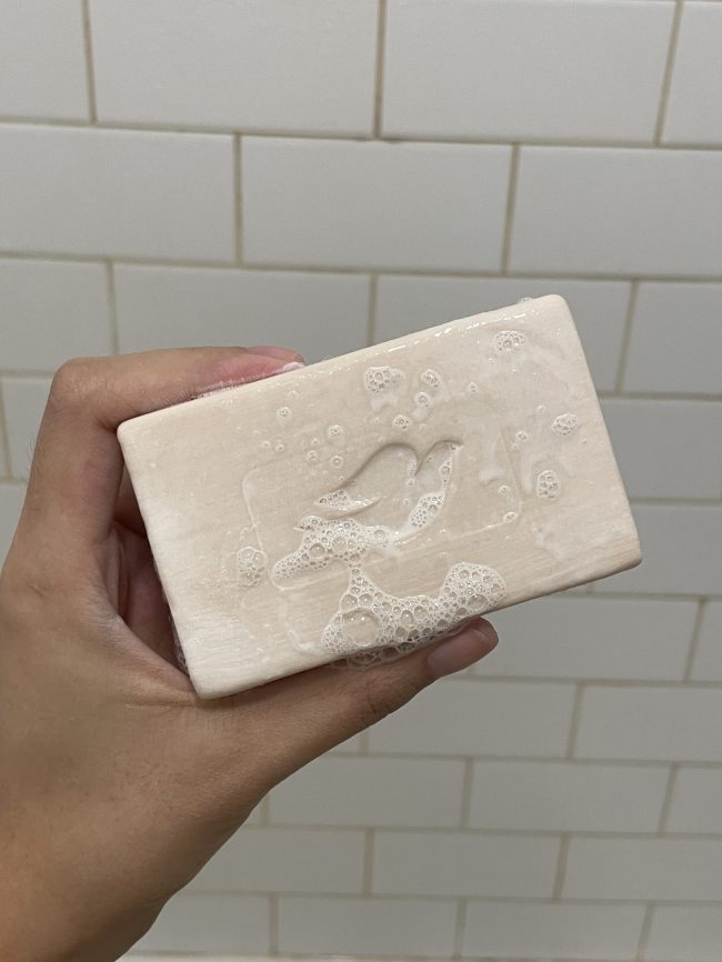 The writer's hand holding a Dove Plant Milk Cleansing Bar