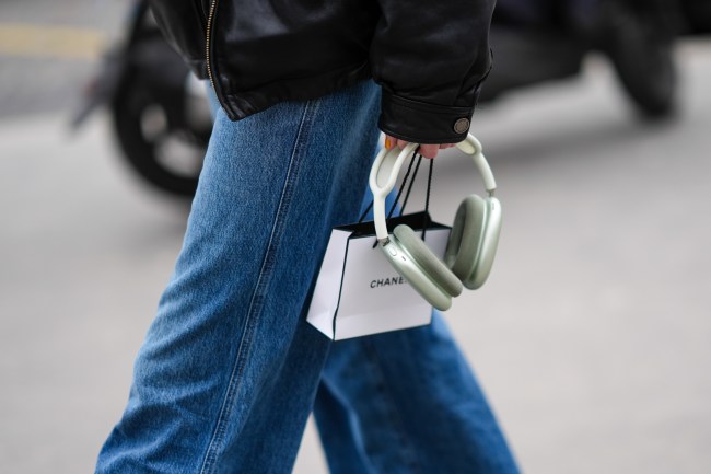 Paris Fashion Week street style shot: a close-up detail view of Apple airpods, Chanel gift bag, and straight blue jeans.