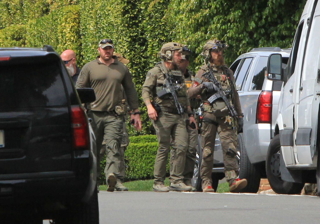 Where's Diddy? Photo of federal agents with guns walking along the street outside Rapper Diddy's house in LA.