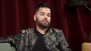 Tim, a white man with black hair and beard in a patterned jacket.