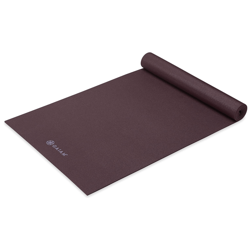 A brown yoga mat partially rolled up