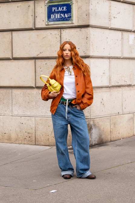 Marie Gaguech in an orange jacket, white tee, and baggy jeans at Paris Fashion Week