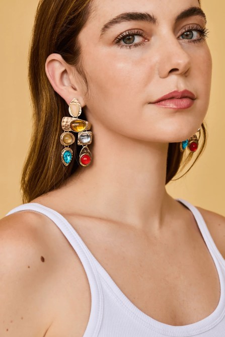 A model wearing Petit Moments Resin Stone Drop Earrings in multiple colors