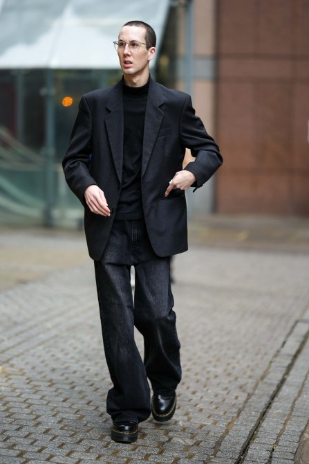 A fashion week guest wearing clear glasses.