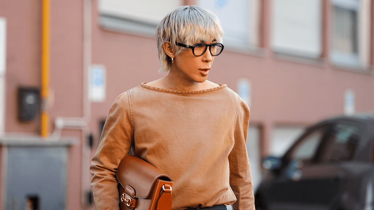 A fashion week guest wearing black aviator glasses.