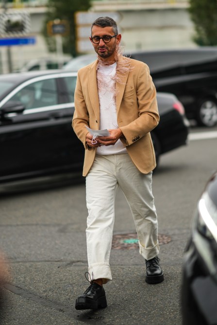 A fashion week guest wearing round glasses.