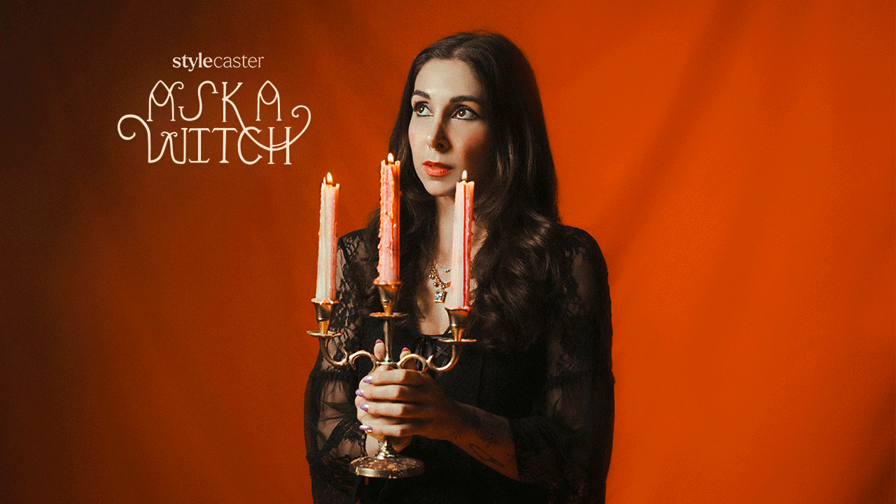 A witch woman holding a lit candelabra with flickering flames, looking up into the cosmos for astrological answers