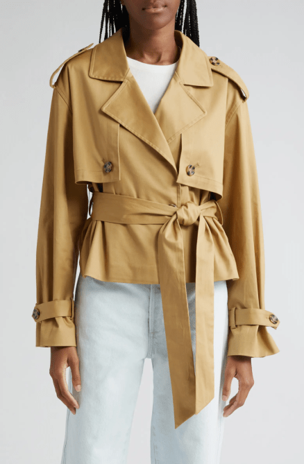 A model wearing the Favorite Daughter The Charles Crop Trench Coat in Sand colorway