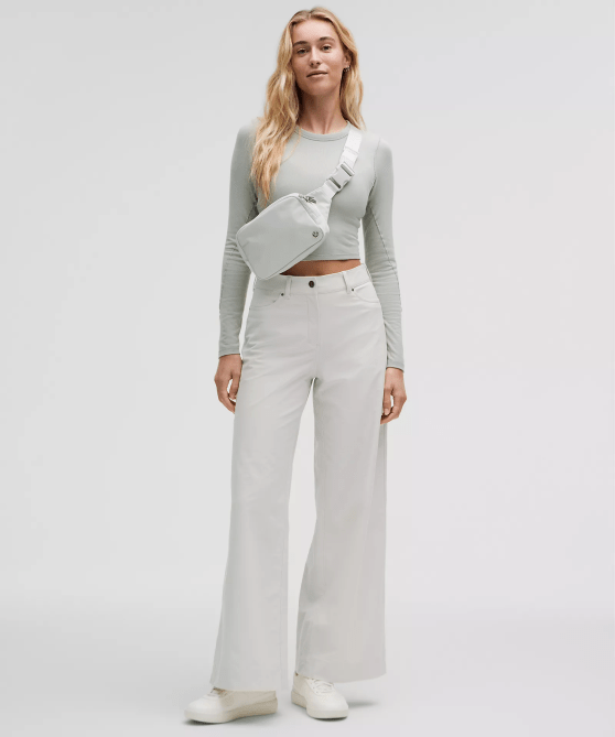 A model wearing the Lululemon Everywhere Belt Bag Large 2L in a light grey-white colorway