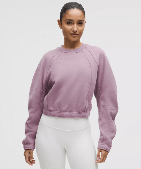 A model wearing the Lululemon Scuba Cropped Relaxed Crewneck in a lavender colorway