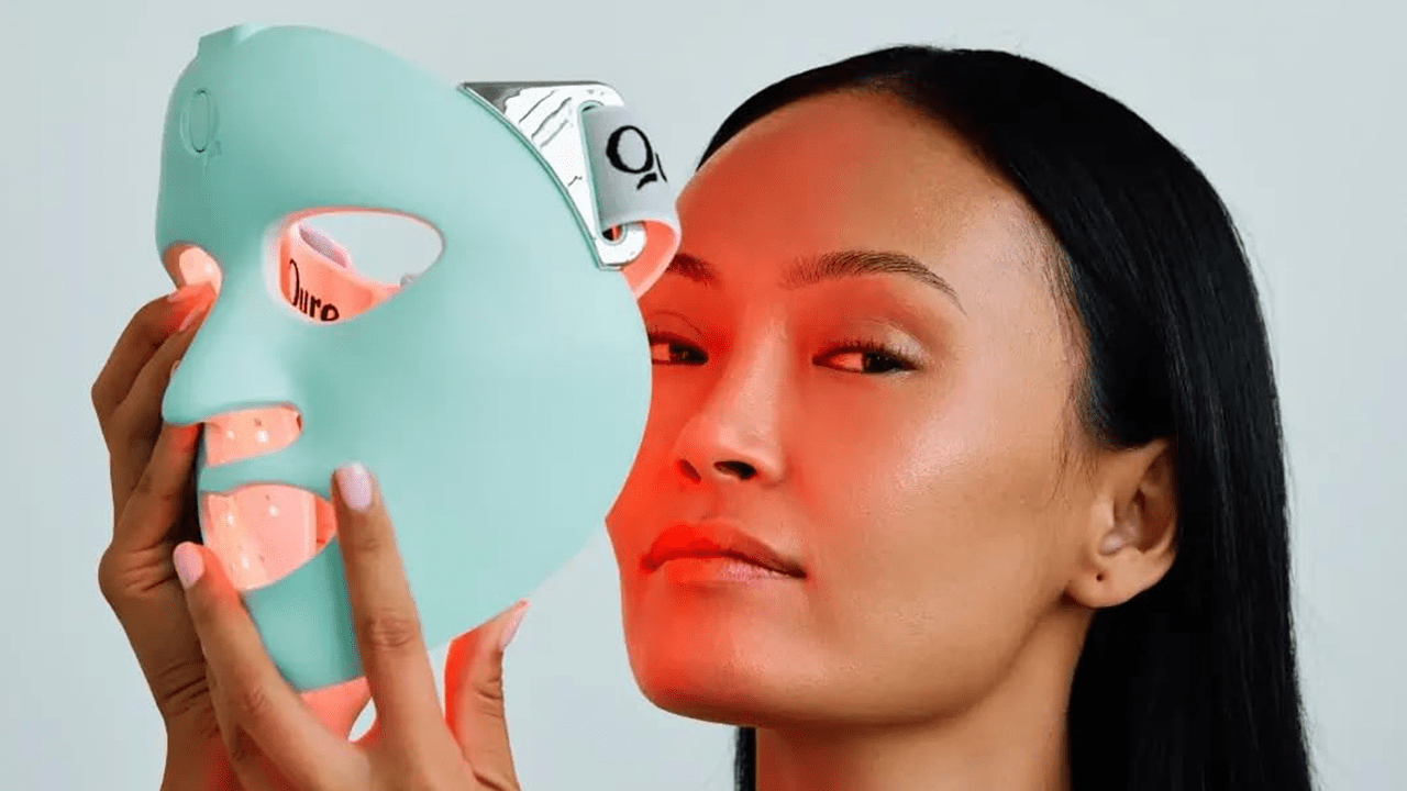 A woman putting on the Qure LED Face Mask